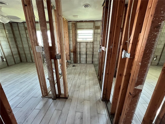 misc room featuring visible vents, ceiling fan, a textured ceiling, and wood finished floors