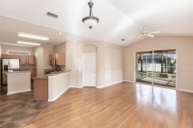 kitchen with appliances with stainless steel finishes, open floor plan, visible vents, and wood finished floors