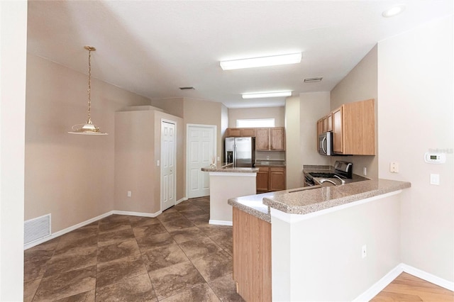 kitchen featuring a center island, stainless steel appliances, visible vents, hanging light fixtures, and baseboards