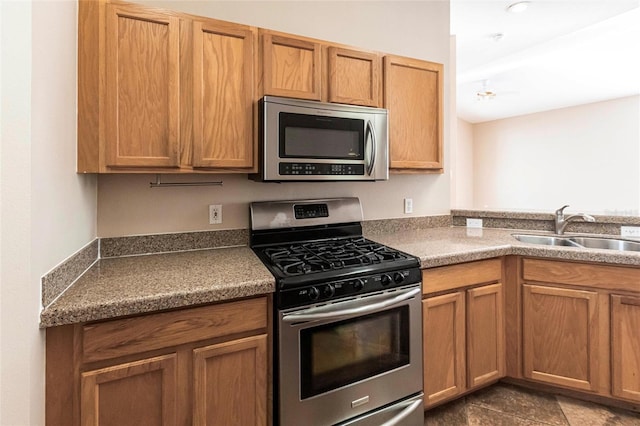 kitchen featuring stainless steel appliances, brown cabinetry, and a sink