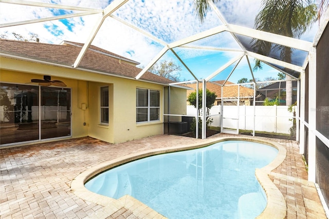 view of pool with glass enclosure, fence, a fenced in pool, and a patio