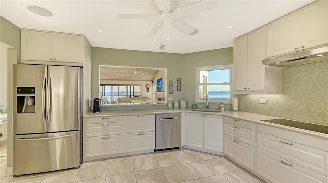 kitchen featuring decorative backsplash, appliances with stainless steel finishes, light countertops, under cabinet range hood, and a sink