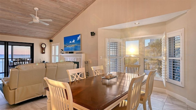 dining space featuring baseboards, a ceiling fan, wood ceiling, vaulted ceiling, and a fireplace