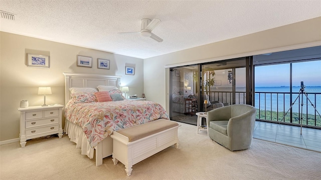 bedroom with access to exterior, carpet, a water view, and visible vents