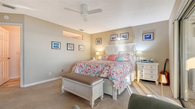 bedroom with light carpet, baseboards, visible vents, and a textured ceiling