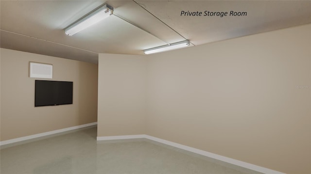 empty room featuring concrete flooring and baseboards