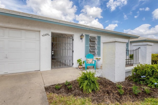 doorway to property with concrete driveway and stucco siding