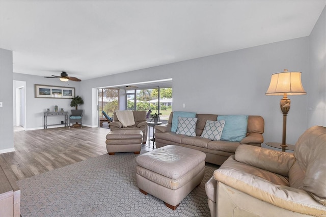 living area with ceiling fan, baseboards, and wood finished floors