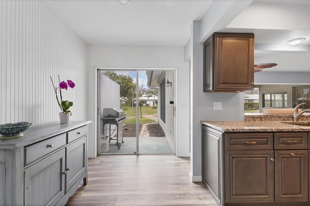 doorway featuring baseboards, a sink, and light wood-style floors