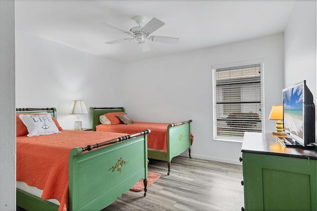 bedroom with light wood-style floors, ceiling fan, and baseboards