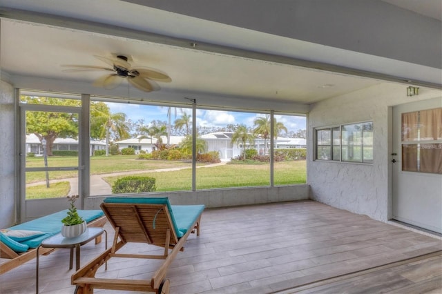 sunroom / solarium featuring a ceiling fan