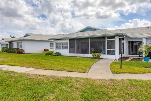 single story home with a front yard, a sunroom, and stucco siding