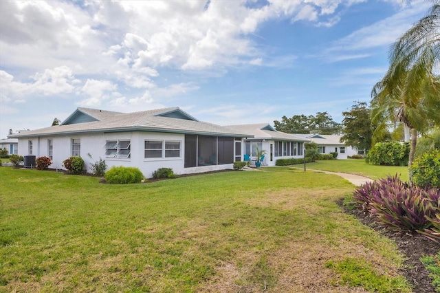 rear view of house featuring a sunroom, a yard, and central AC unit