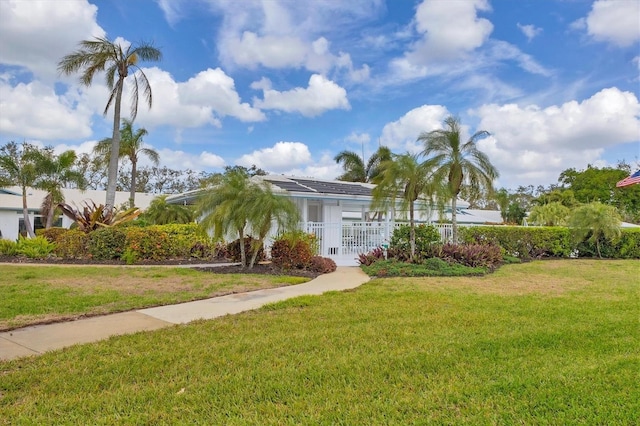 view of front of home with a front yard and fence