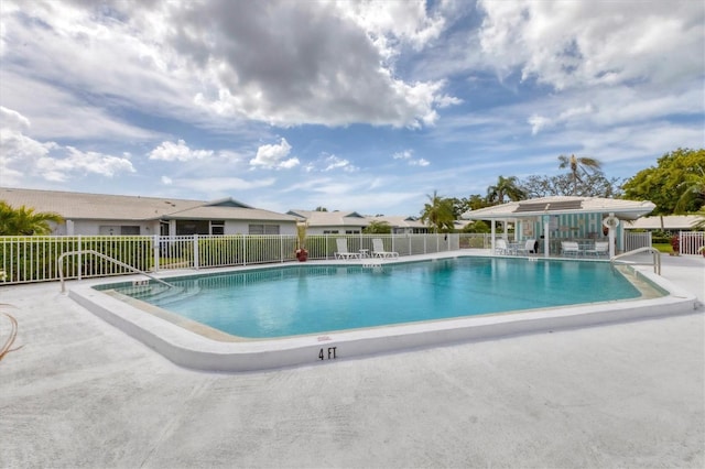 pool with a patio and fence