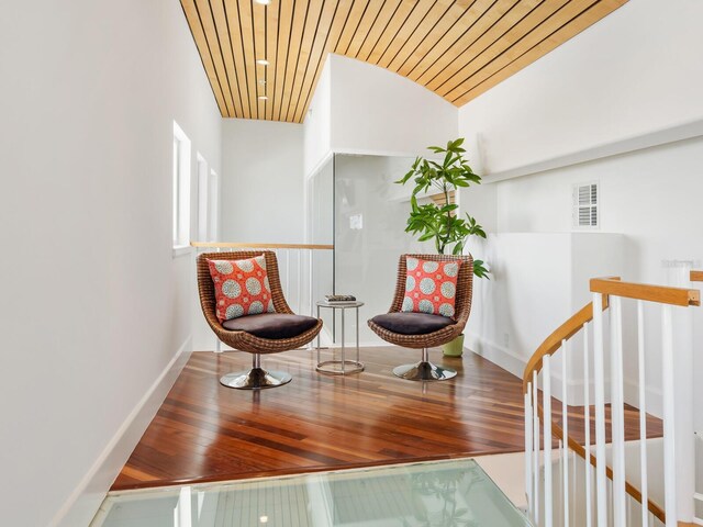 534 Beach Rd, Sarasota, FL 34242 - living area featuring an upstairs landing, visible vents, wood ceiling, and wood-type flooring