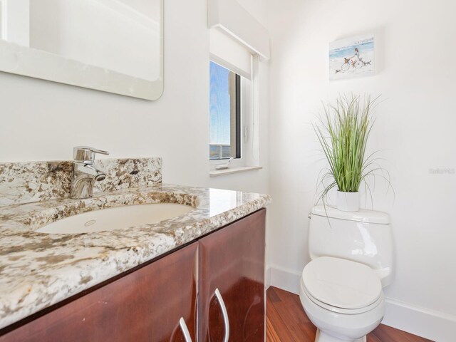 534 Beach Rd, Sarasota, FL 34242 - bathroom featuring vanity, toilet, wood finished floors, and baseboards