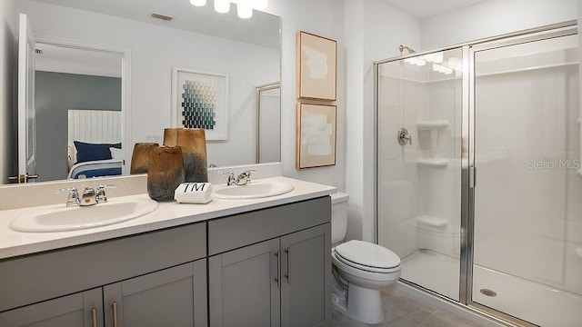 bathroom featuring a stall shower, a sink, and toilet