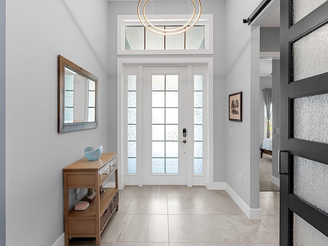 foyer entrance with light tile patterned flooring and baseboards