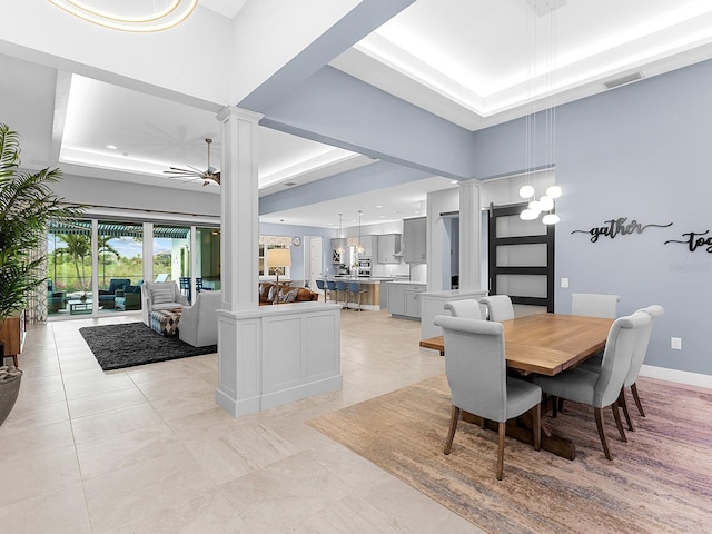 dining room featuring a ceiling fan, visible vents, ornate columns, baseboards, and a raised ceiling