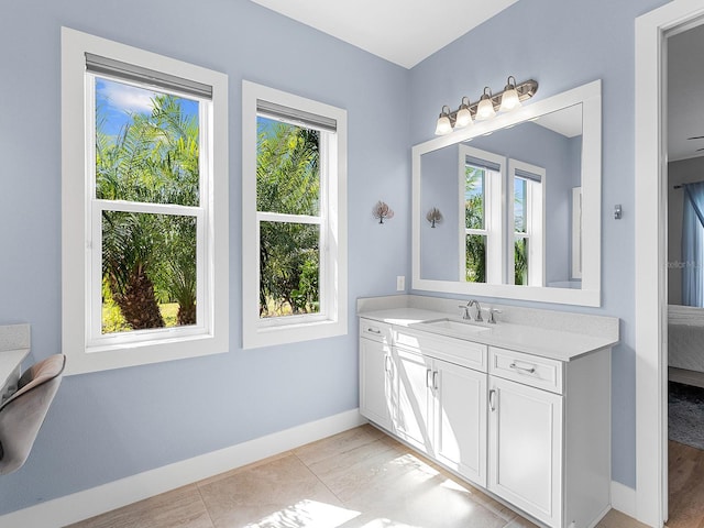 bathroom featuring tile patterned floors, baseboards, and vanity