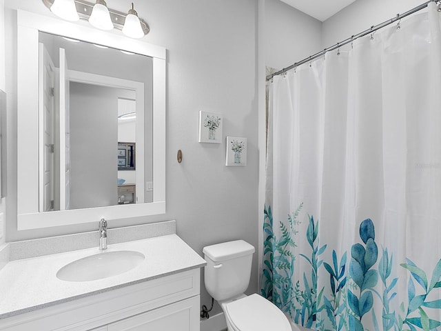 bathroom with toilet, vanity, and a shower with curtain