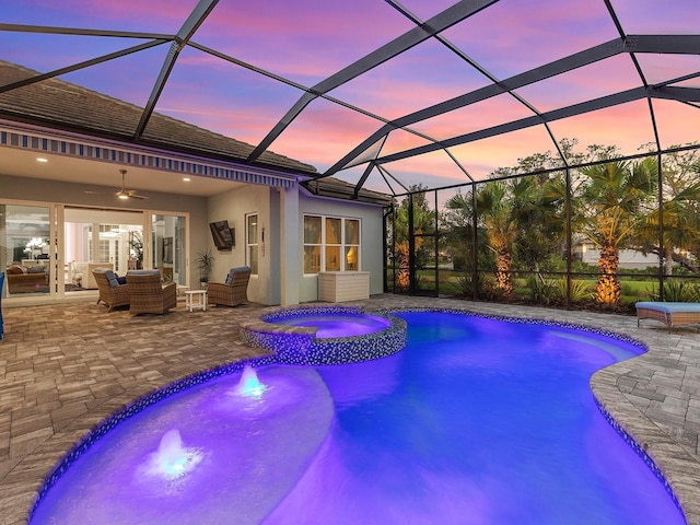 view of pool featuring a pool with connected hot tub, an outdoor living space with a fire pit, a ceiling fan, and a patio area