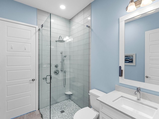 bathroom featuring recessed lighting, a shower stall, toilet, and vanity