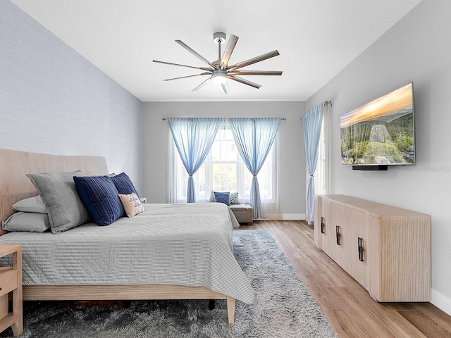 bedroom featuring baseboards, light wood-type flooring, and ceiling fan