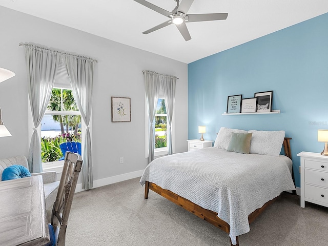 bedroom featuring multiple windows, carpet flooring, a ceiling fan, and baseboards