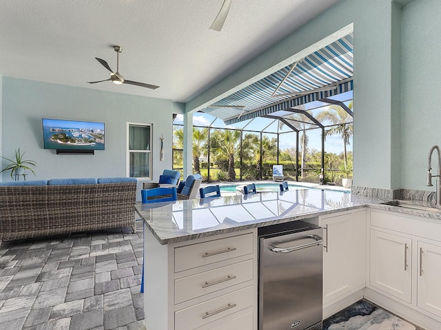 kitchen featuring a healthy amount of sunlight, open floor plan, a sunroom, and a sink