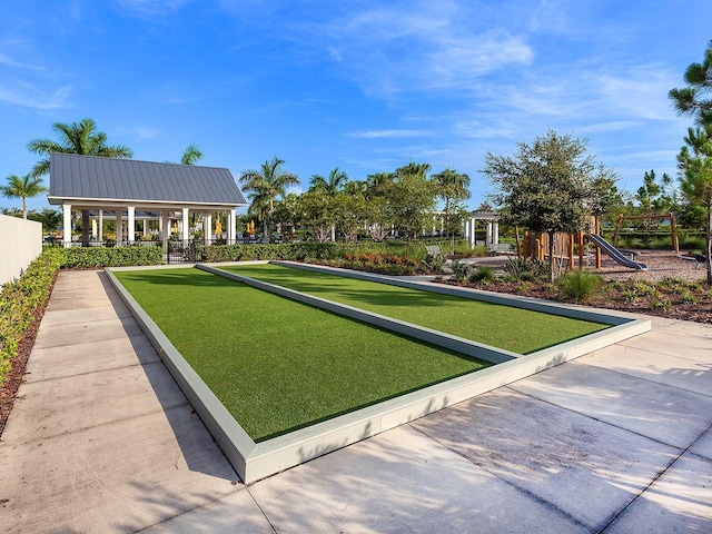 view of home's community featuring playground community and fence