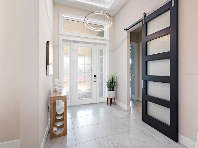 813 Tailwind Pl, Sarasota, FL 34240 - entrance foyer featuring a barn door, a towering ceiling, baseboards, and light tile patterned floors