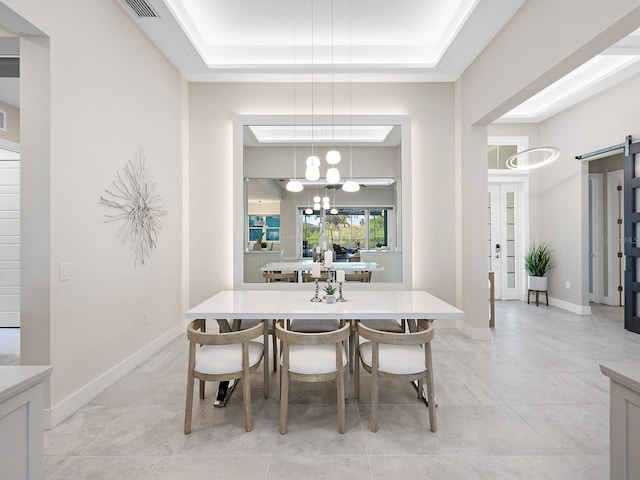 813 Tailwind Pl, Sarasota, FL 34240 - dining area featuring a raised ceiling, a barn door, a chandelier, and baseboards