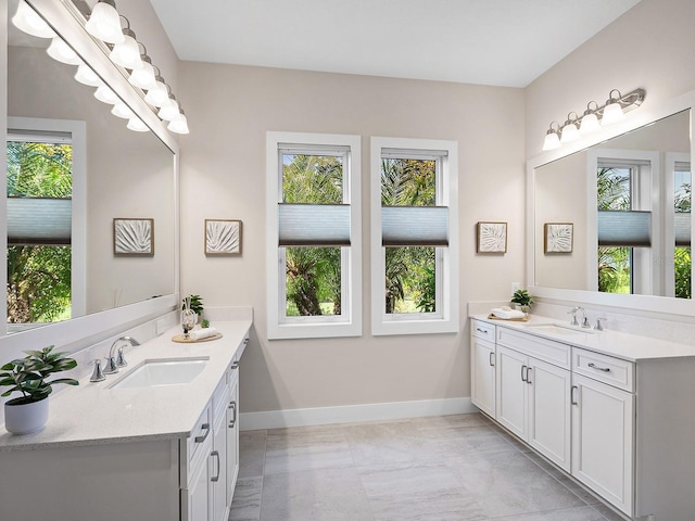 813 Tailwind Pl, Sarasota, FL 34240 - full bathroom with two vanities, baseboards, and marble look tiles
