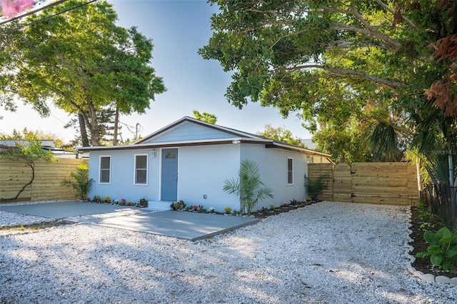 view of front facade with a gate, fence, and stucco siding