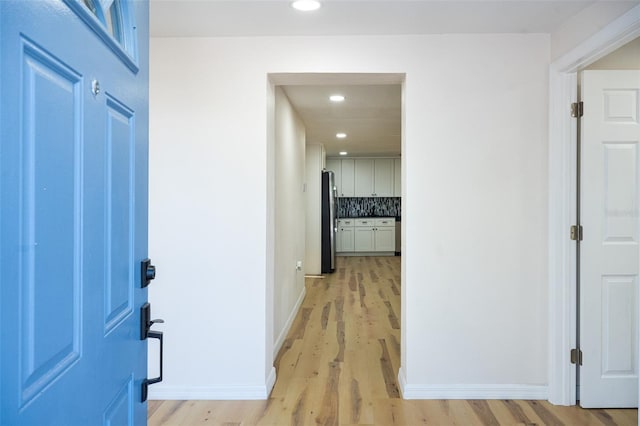 corridor featuring recessed lighting, baseboards, and light wood finished floors