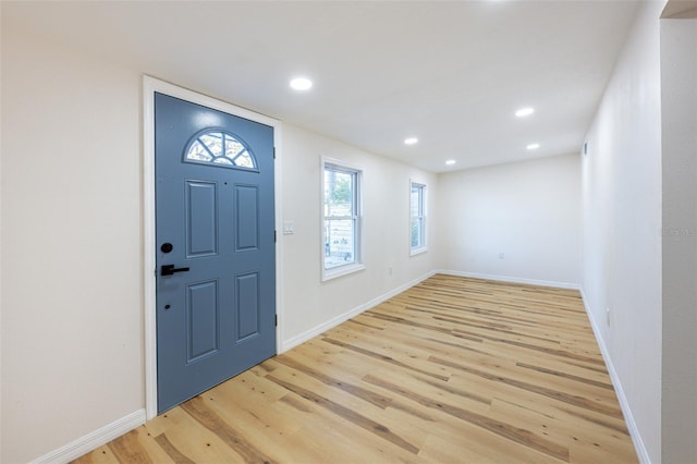 foyer entrance with recessed lighting, light wood-style floors, and baseboards