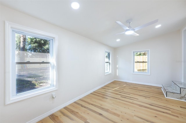 spare room featuring vaulted ceiling, recessed lighting, light wood-style floors, and baseboards