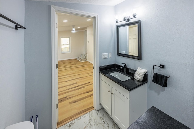 half bathroom featuring vanity, recessed lighting, and marble finish floor