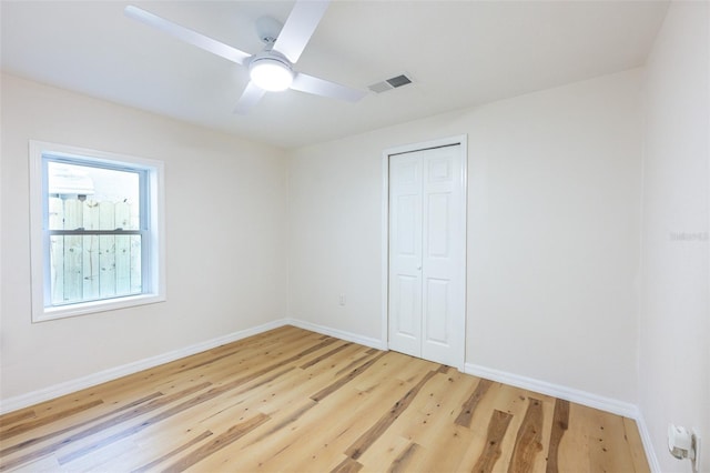 spare room with visible vents, baseboards, light wood-style floors, and a ceiling fan