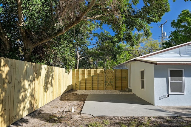 view of yard with a fenced backyard and a gate