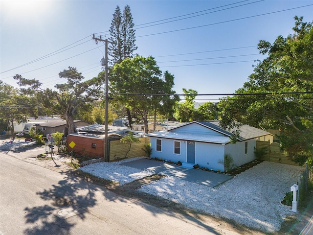 view of front of property featuring stucco siding, driveway, and fence