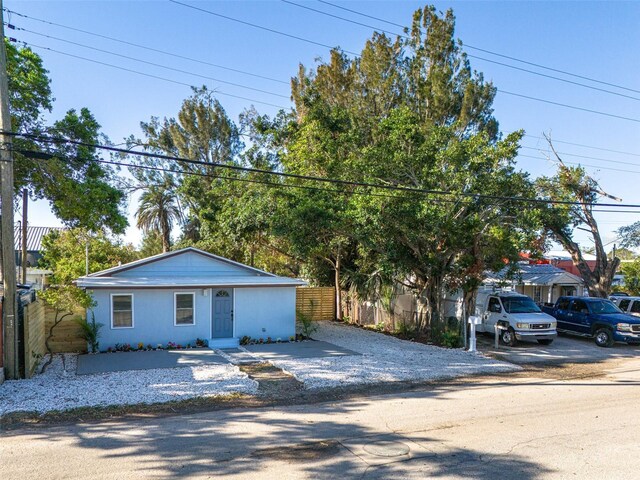 view of front of property with gravel driveway and fence