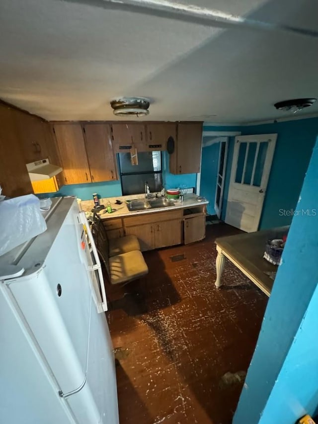 kitchen with freestanding refrigerator and a sink