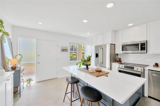 kitchen featuring recessed lighting, stainless steel appliances, and a kitchen breakfast bar