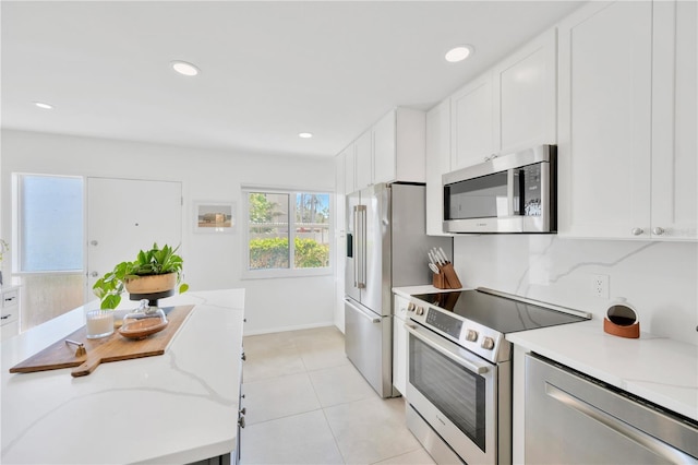 kitchen with white cabinets, light stone countertops, stainless steel appliances, and recessed lighting