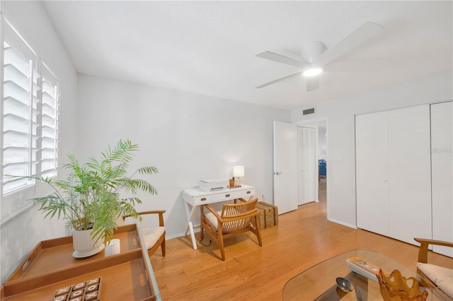 office area featuring light wood-style floors, visible vents, ceiling fan, and baseboards