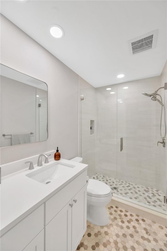 full bath featuring toilet, a shower stall, visible vents, and vanity