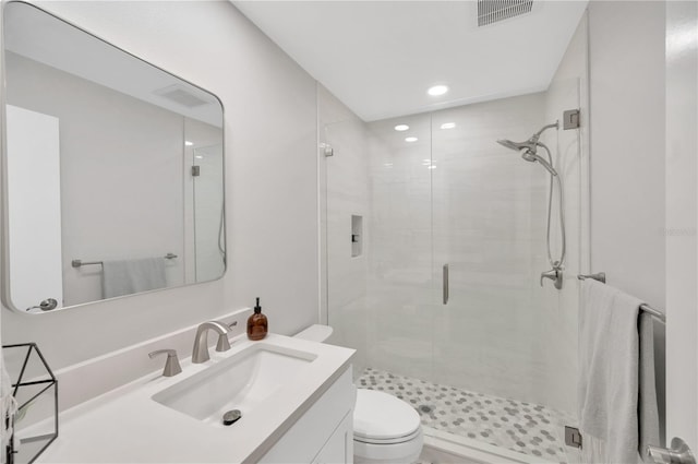 full bath with a stall shower, visible vents, vanity, and toilet